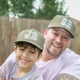 Family wearing matching personalised grey baseball caps with their initials. Cubs & Co. Australia.