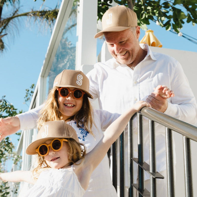 Family wearing matching personalised grey baseball caps with their initials. Cubs & Co. Australia.